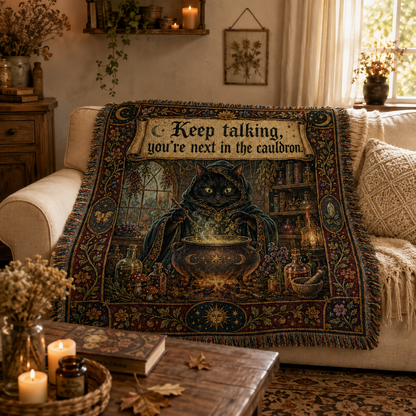 Black cat cauldron woven blanket draped over a cream sofa in a cozy cottage living room