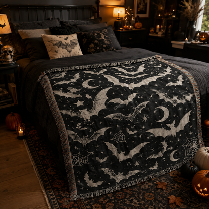 Black celestial bat woven throw blanket across a moody Halloween bedroom bed