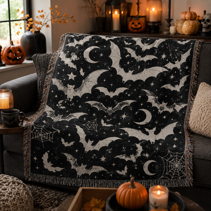 Celestial bat Halloween woven blanket styled on a cozy sofa with pumpkins and candlelight