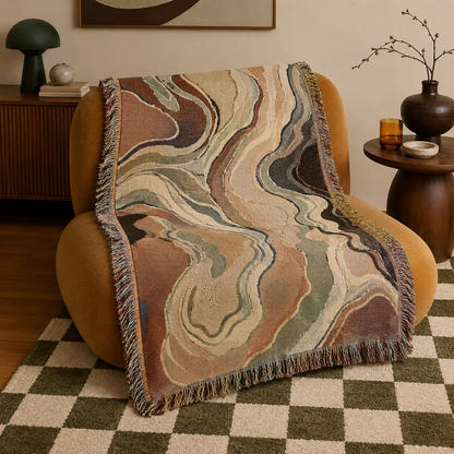 EarthFlow abstract woven blanket with organic marbled contour pattern draped over a curved lounge chair