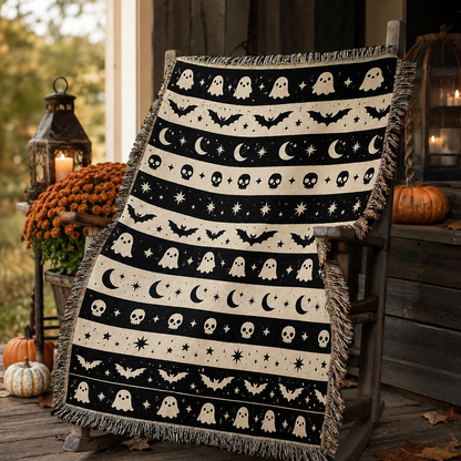 Ghost bat moon woven Halloween blanket on a rustic autumn porch with pumpkins and lanterns