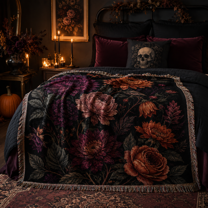 Dark floral woven blanket styled across a gothic Halloween bedroom with burgundy pillows pumpkins and candlelight