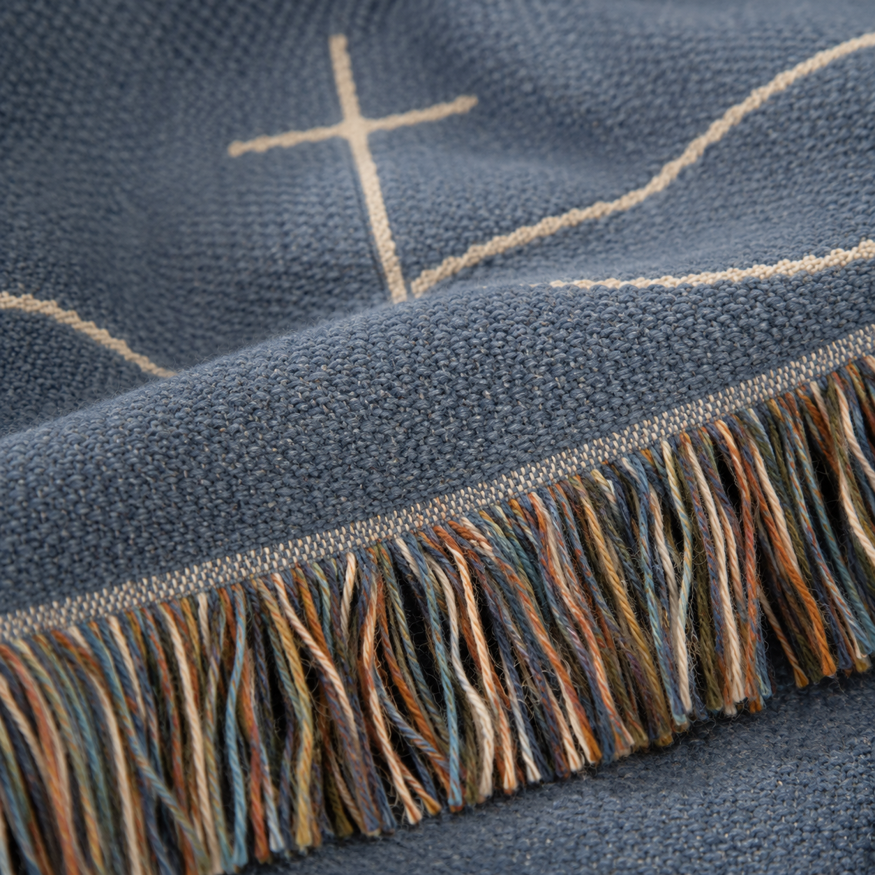 Macro close-up of woven yarn texture and multicolor fringe on Christian blanket
