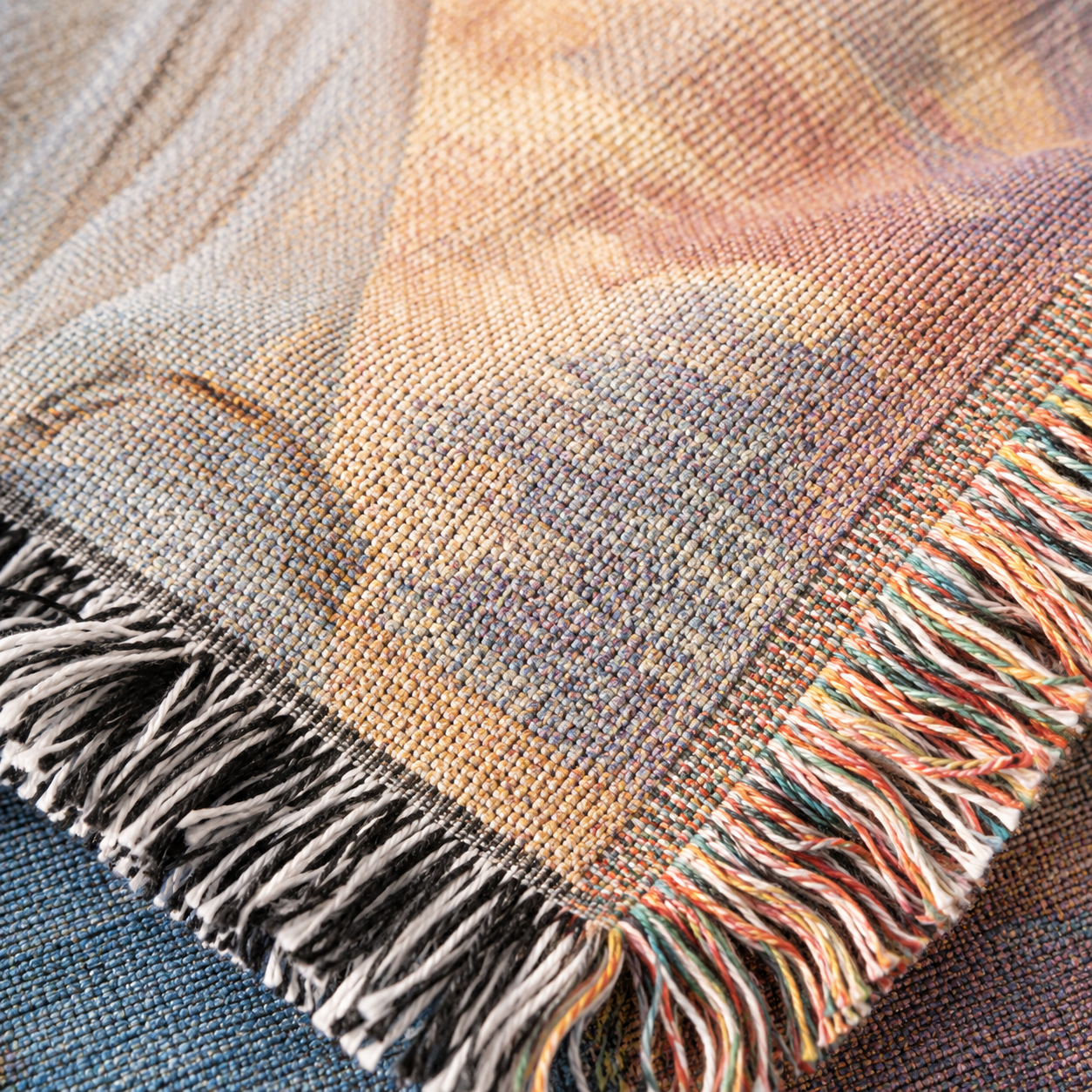 Macro close-up of woven yarn texture and multicolor fringe on Jesus sunrise blanket