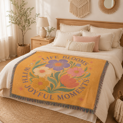 Life Blooms floral woven blanket displayed across a boho bed