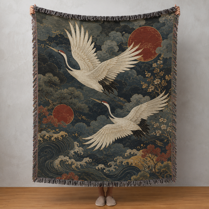 Japanese-inspired woven blanket with two white cranes, red suns, indigo clouds and ocean waves
