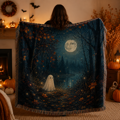 Moonlit ghost forest woven blanket held up in a warm Halloween home interior
