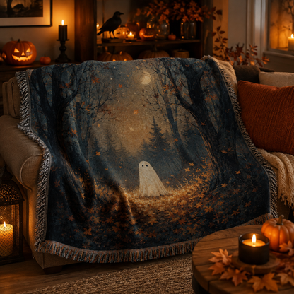 Soft moonlit ghost forest woven blanket draped over a Halloween sofa