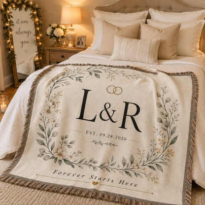 Personalized botanical monogram wedding woven blanket styled across a romantic bedroom bed