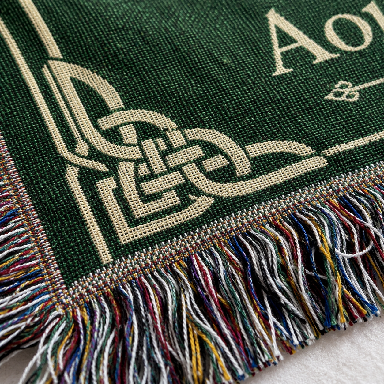 Macro detail of Celtic Tree of Life wedding woven blanket showing woven texture and multicolor fringe