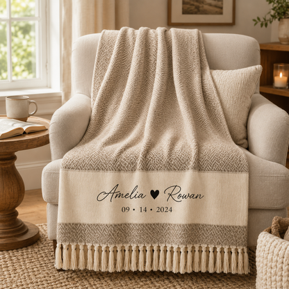 Personalized couple woven throw blanket draped over a cozy armchair in a warm reading nook