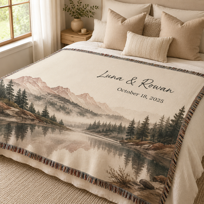 Personalized mountain lake woven blanket with custom couple names and date styled on a neutral bedroom bed