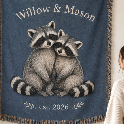Close-up of personalized raccoon couple woven blanket showing names, established year, woven texture and fringe