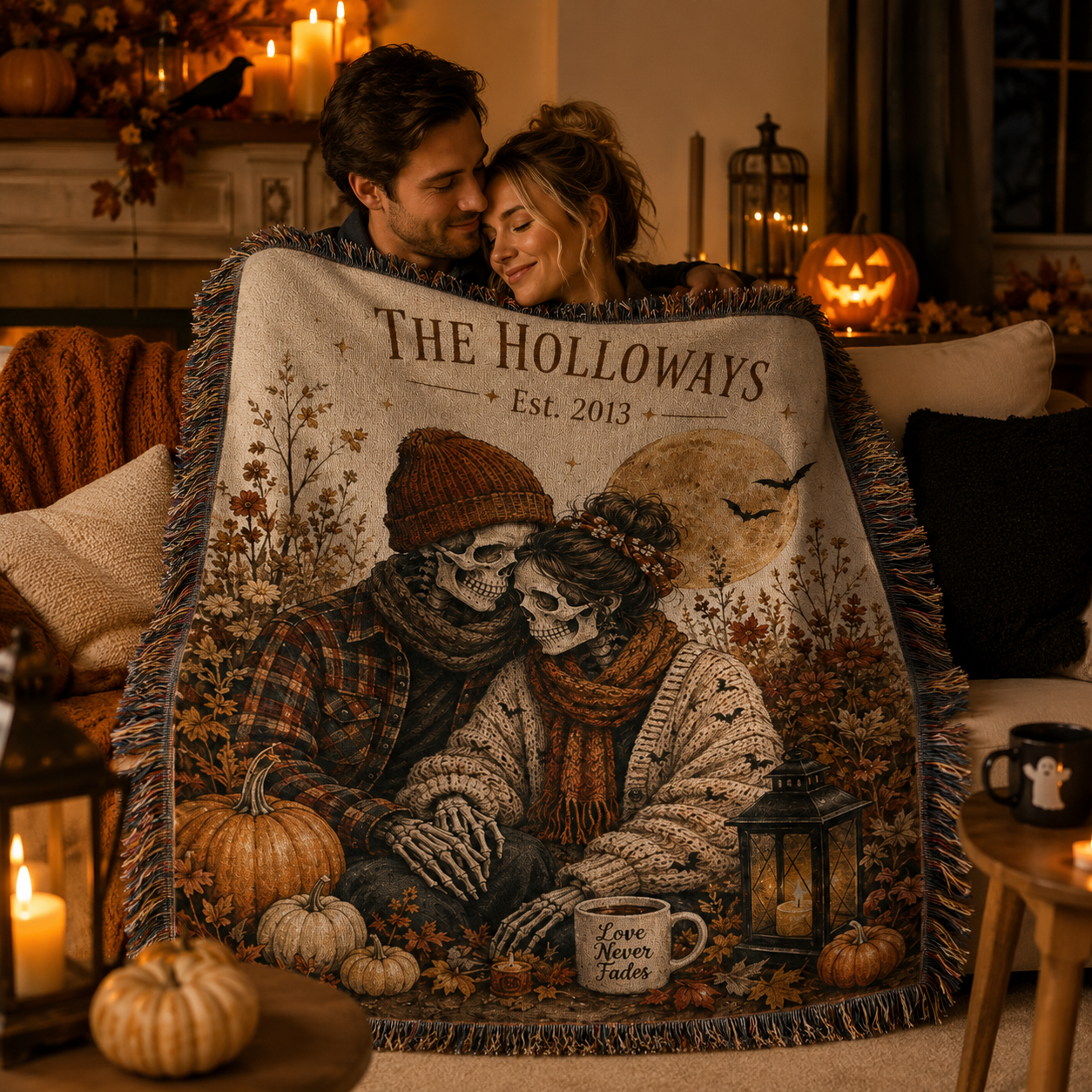 Couple wrapped in a personalized skeleton couple Halloween woven blanket beside candles pumpkins and a glowing jack o lantern