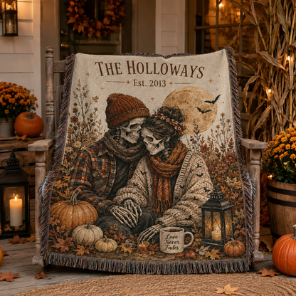 Personalized skeleton couple Halloween woven blanket displayed on a rustic porch with pumpkins lanterns mums and corn stalks