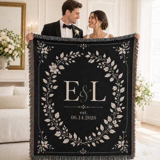 Newlywed couple holding personalized black botanical woven blanket