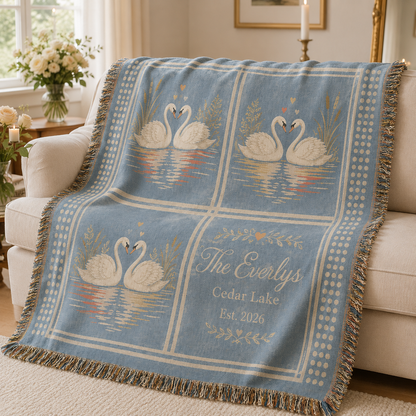 Personalized swan wedding woven blanket softly draped on a cream sofa