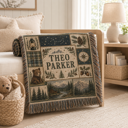 Personalized woodland woven blanket draped over a light wood nursery bench