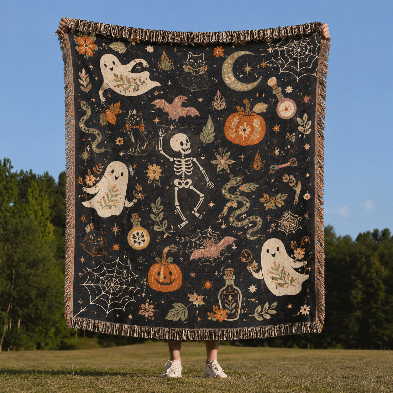 Whimsical Halloween folk art woven blanket with ghosts, skeleton, black cats, pumpkins, bats and fringe